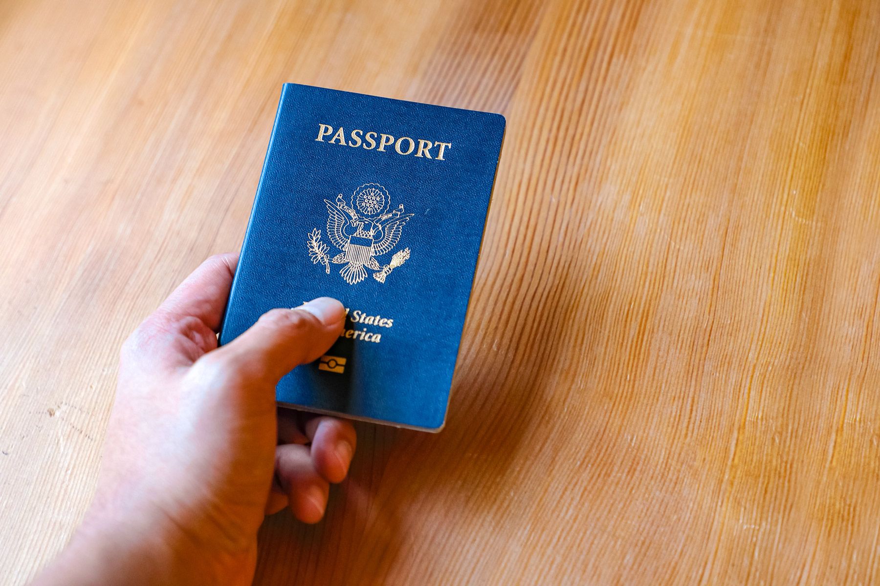 man-hand-holding-us-passport