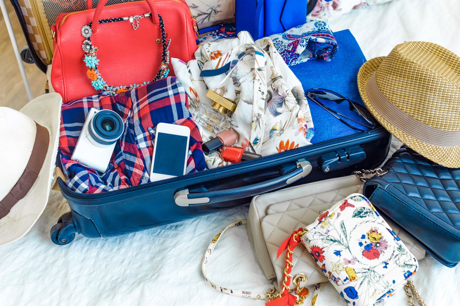 womans-suitcase-being-packed-on-a-bed